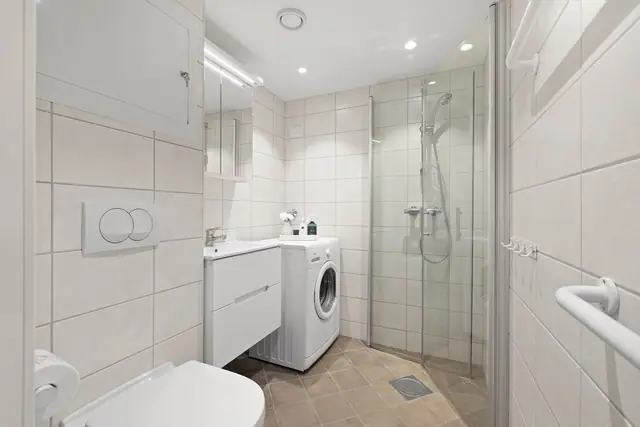 Lekkert bad med downlights i tak og varmekabler i gulv.