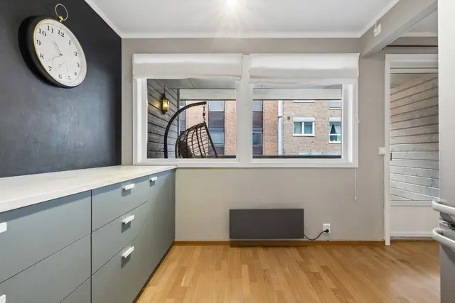 Kjøkkenet har innredning med glatte fronter og benkeplate av laminat.