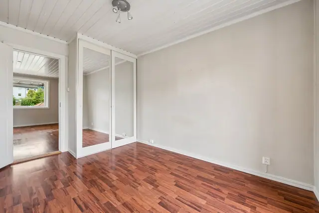 Romslig hovedsoverom med praktisk skyvedørsgarderobe og god plass til dobbeltseng.