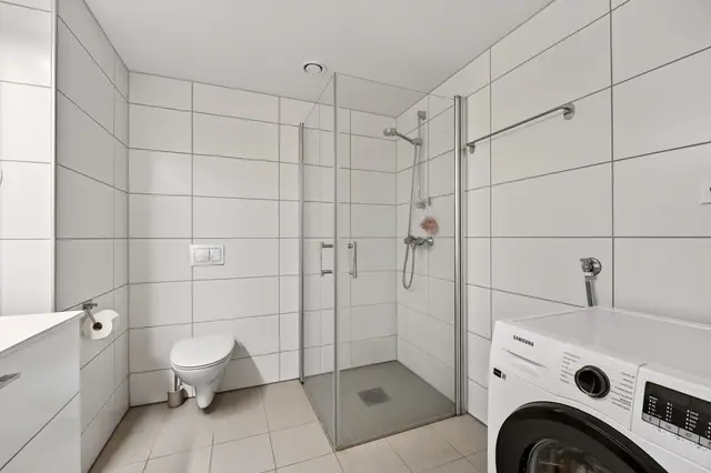 Badet fremstår lyst og pent med varmekabler i gulvene.