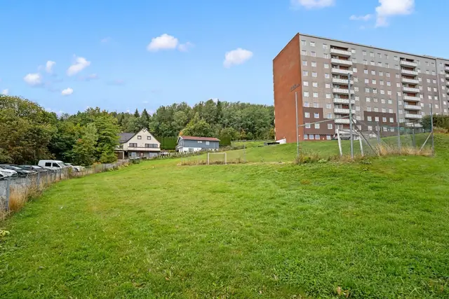 Oversiktsbilde av bebyggelsen med grønne utearealer rundt, her får man et godt inntrykk av områdets åpne preg!